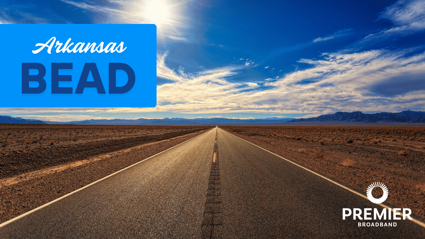 A straight road stretches into a desert landscape under a blue sky with clouds. Text reads Arkansas BEAD projects on a blue box, highlighting fiber-only broadband, with the Premier Broadband logo in the lower right corner.