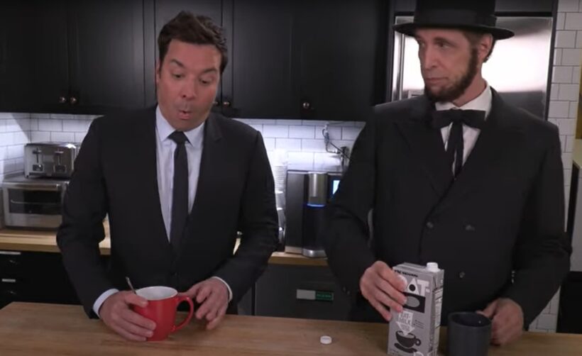 Two men in suits making coffee.