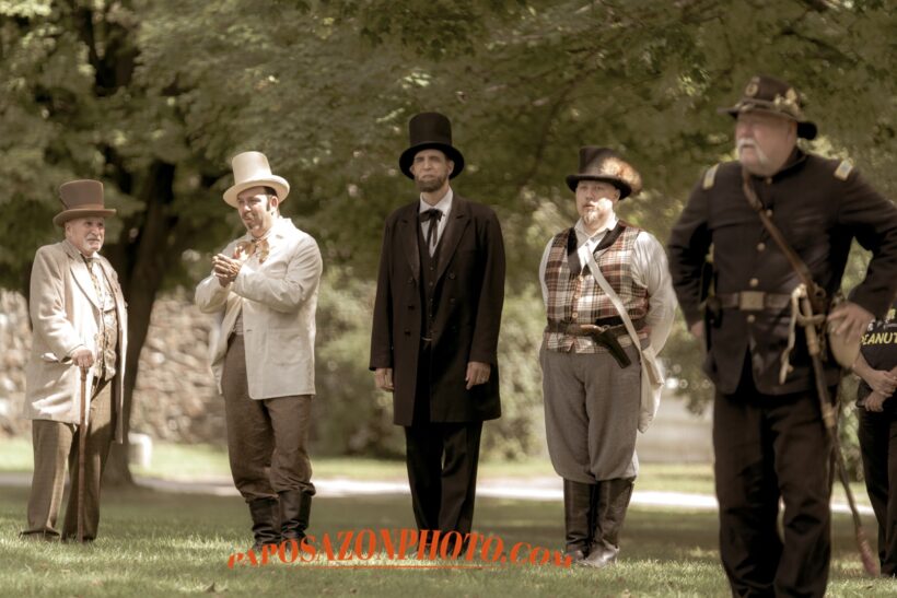 Historical reenactors in period costumes outdoors.